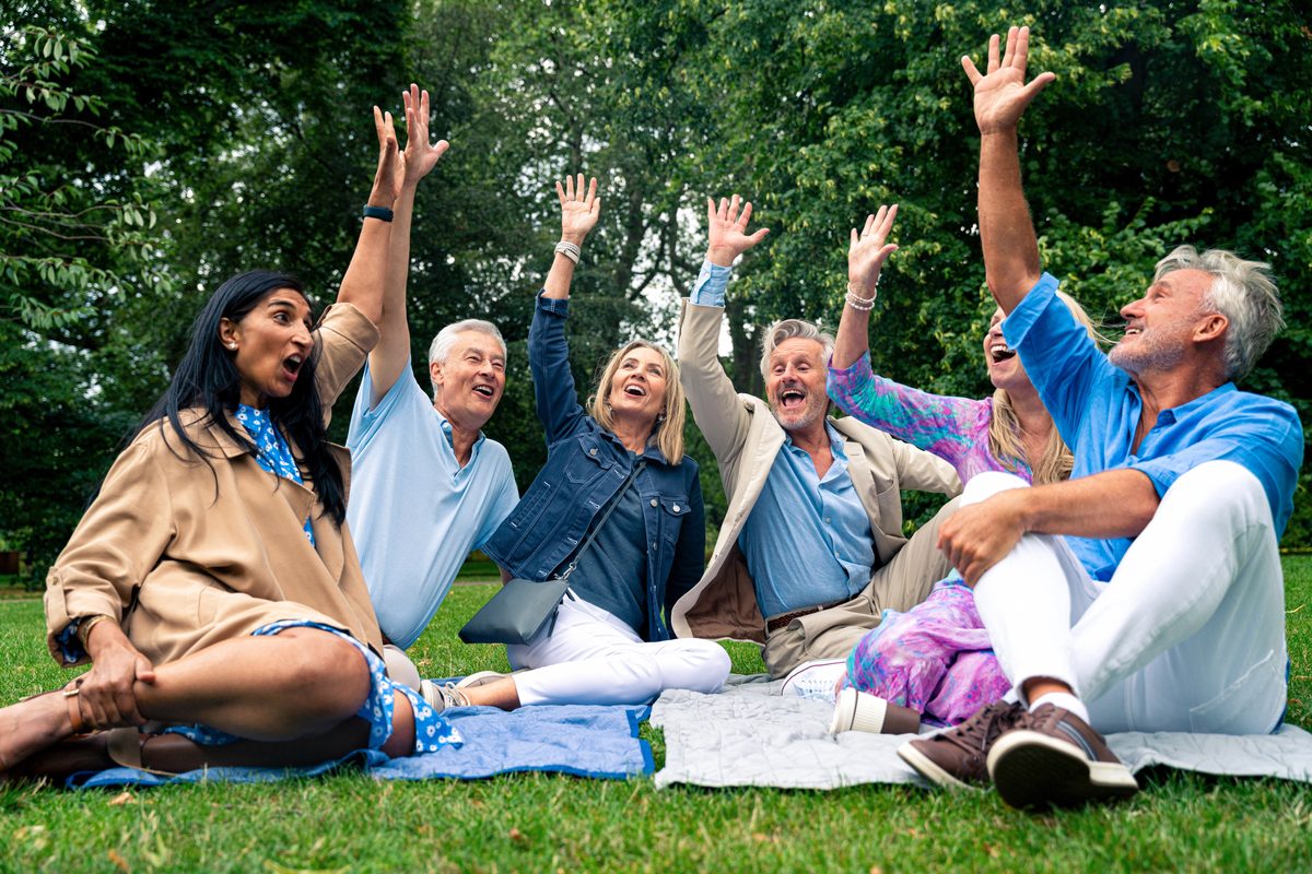 A diverse group of older adults laughing together outdoors